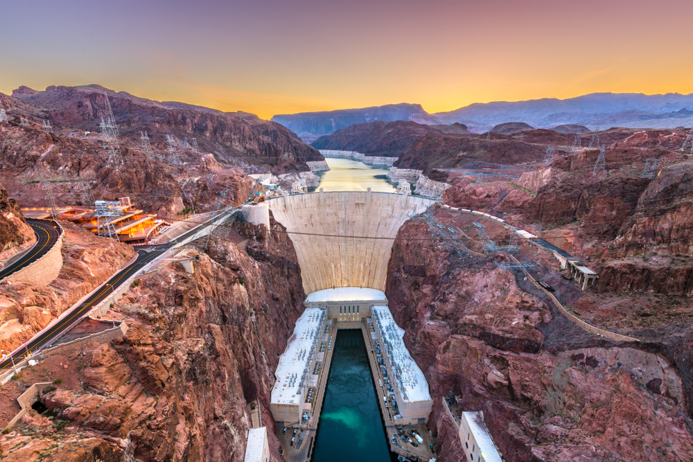 Hoover Dam on the Colorado River straddling Nevada and Arizona at dawn from above.