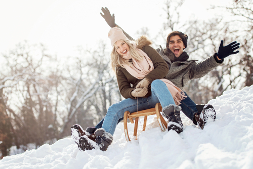 Two people having a great time sledding.