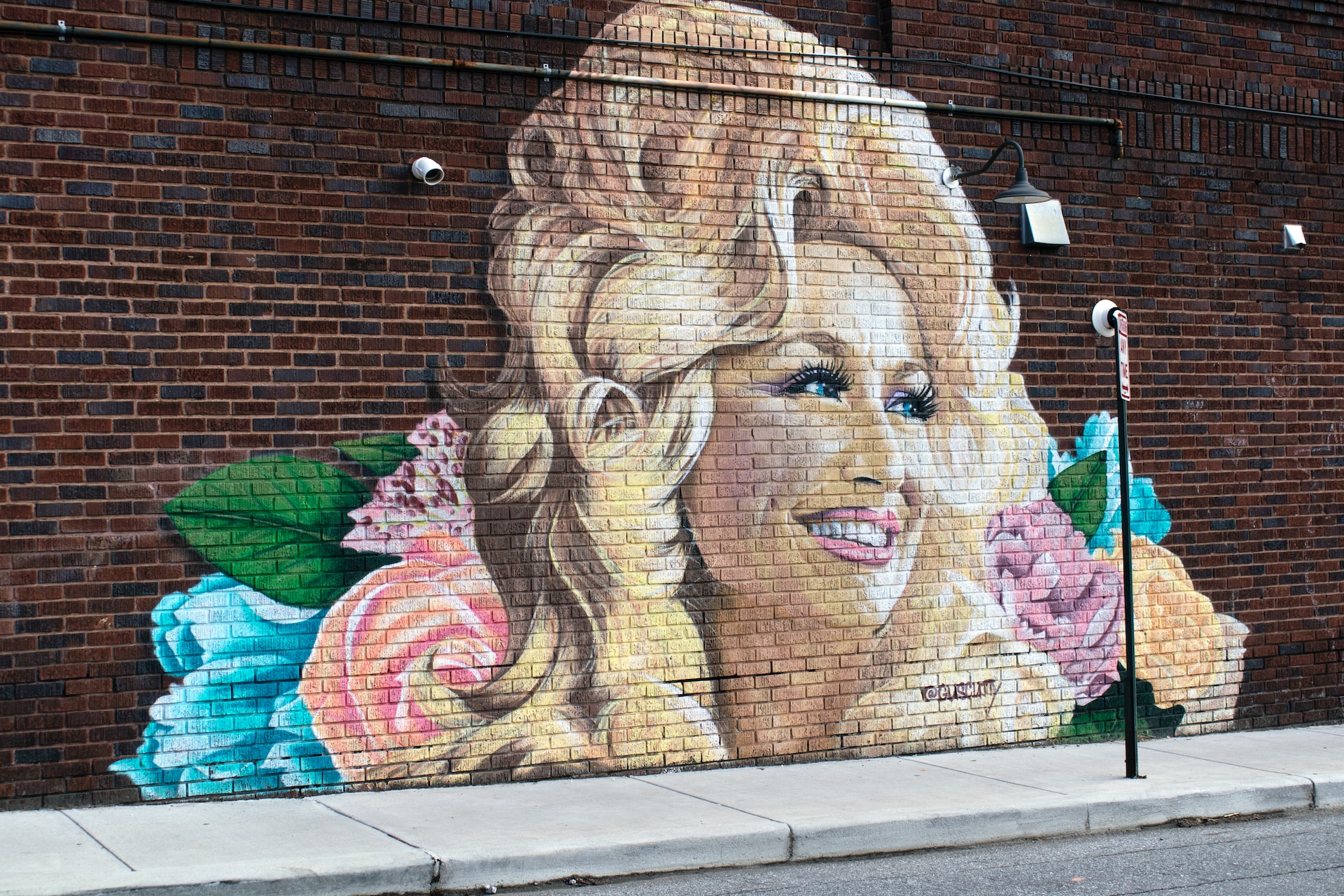 A mural of Dolly Parton on bricks.