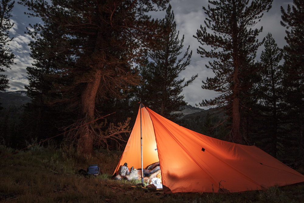 Camping in a lit up tent in the wilderness in Yosemite National Park.