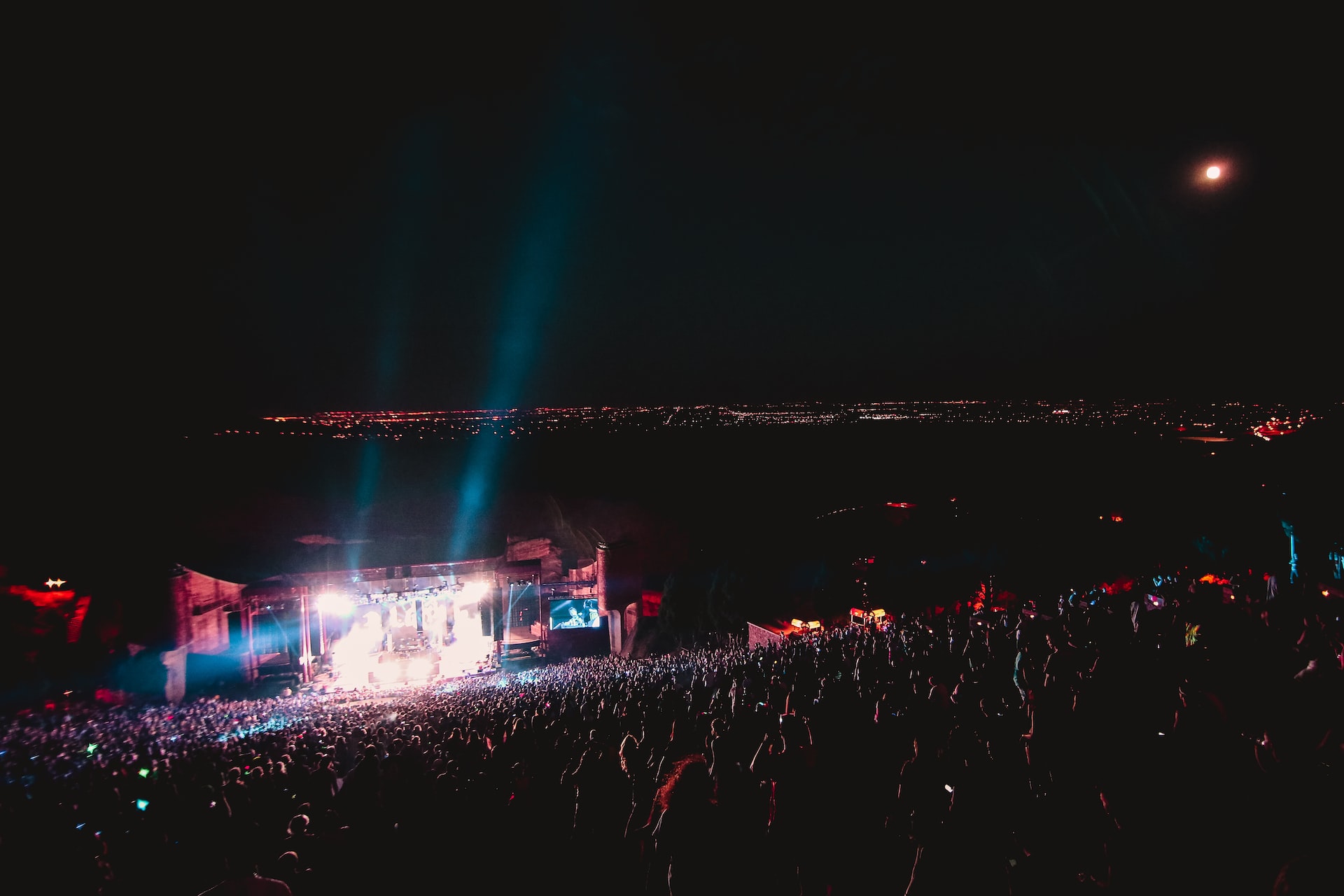 Red Rocks Amphitheater lit-up at night with a large crowd. 