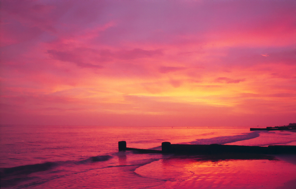 The sky lit up in hues of pink, red, and orange at Madeira Beach, Florida.