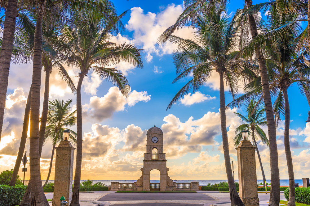 Palm Beach, Florida, clock tower on Worth Ave surrounded by palm trees.