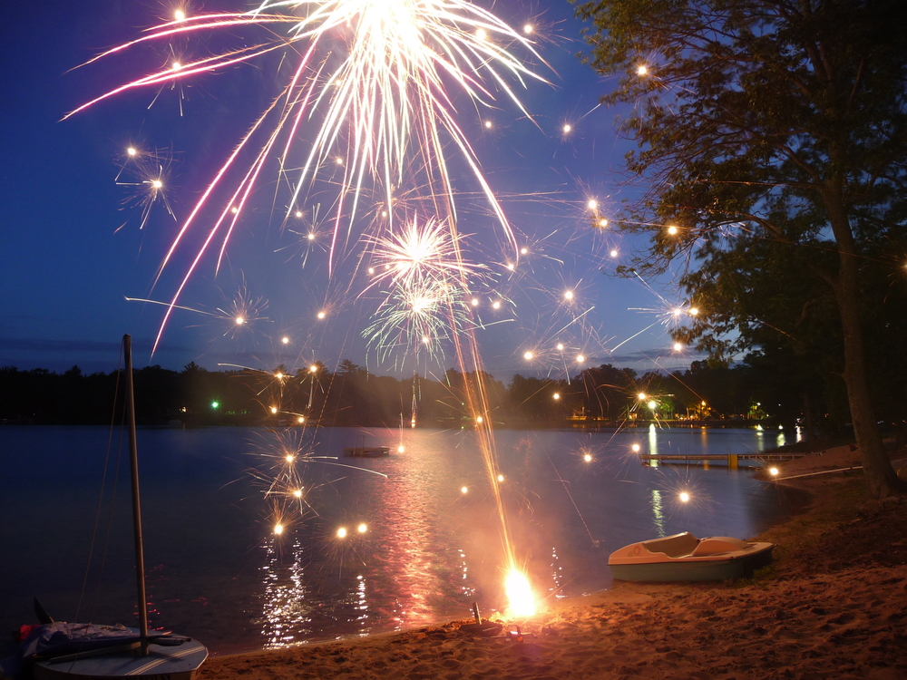 Roman Candle fireworks being set off at night lakeside.
