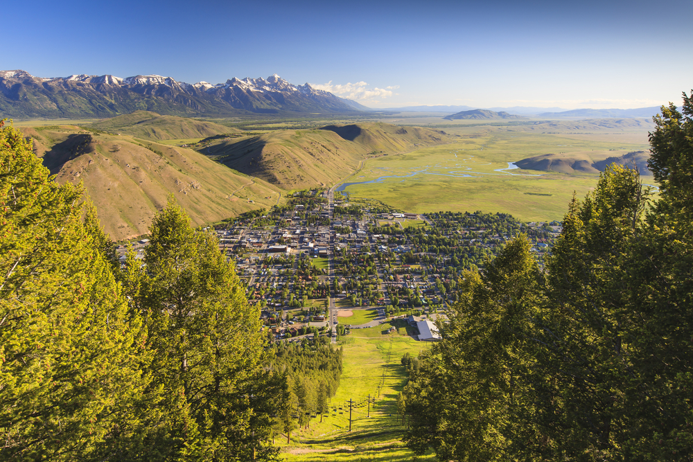 Aerial view of the city of Jackson in the springtime with green meadows and mountains.