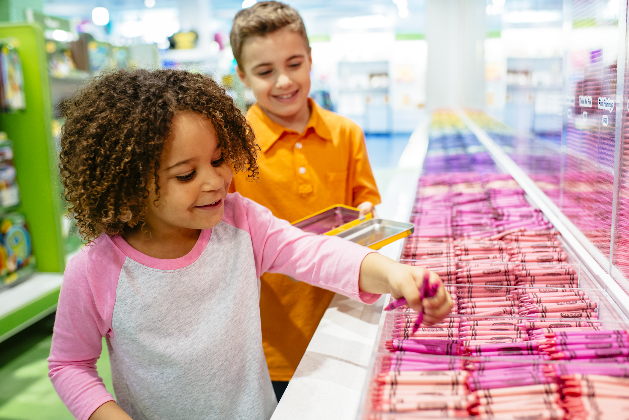 Two kids picking out crayons at the Crayola Factory.