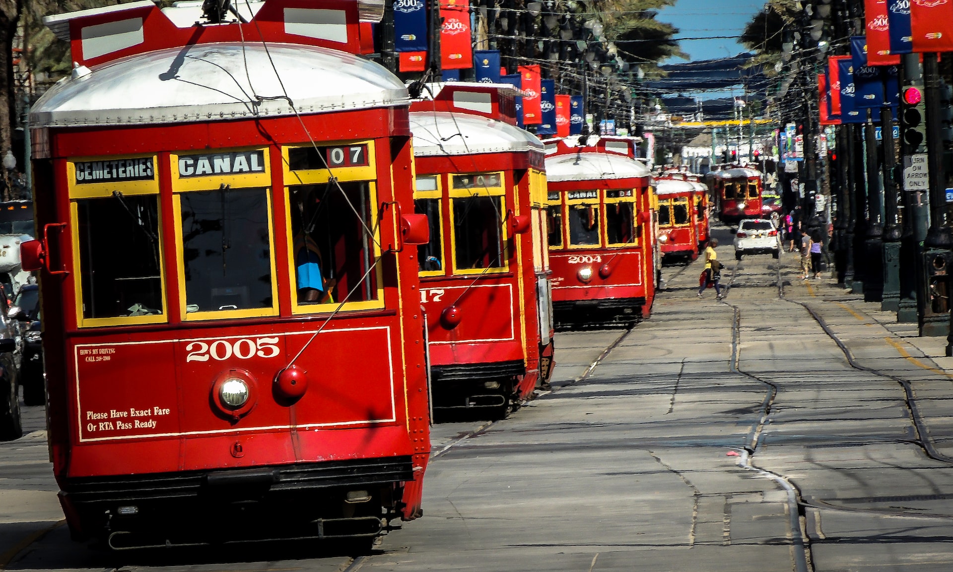 A line of bright red Canal streetcars going down the street.