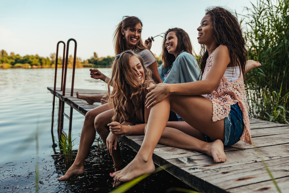 Female friends enjoying a sunny day by the lake.