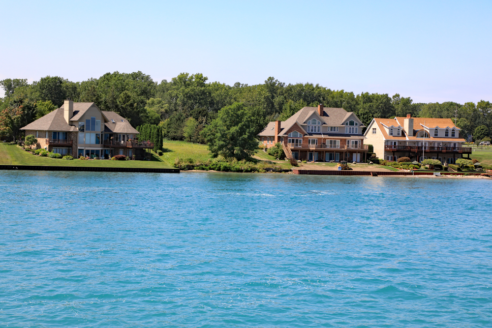 Three large cottages along a lake.