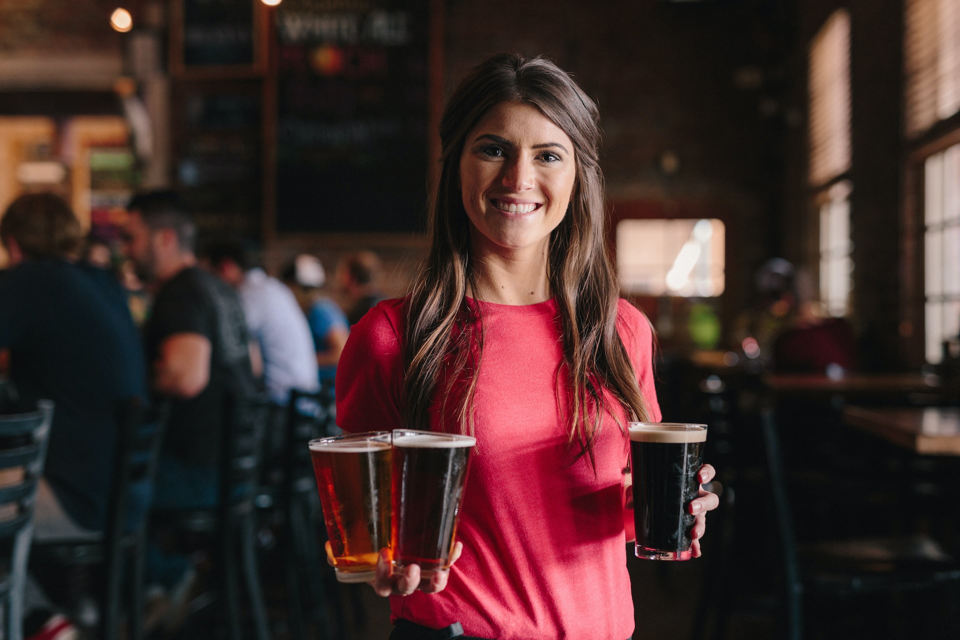 A woman serving beer at a pub.