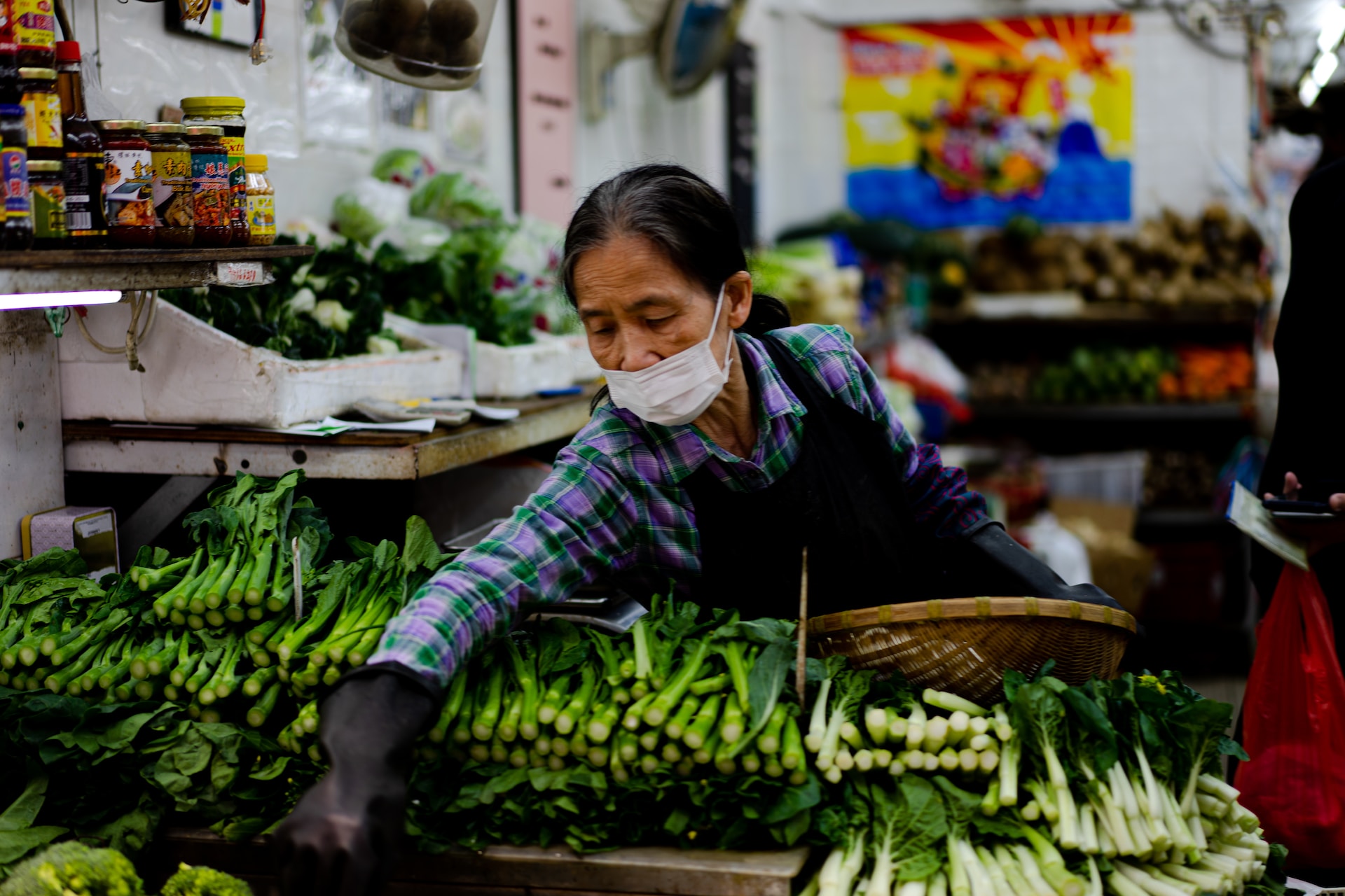 A woman stacking vegetables in Tin Hau Market.