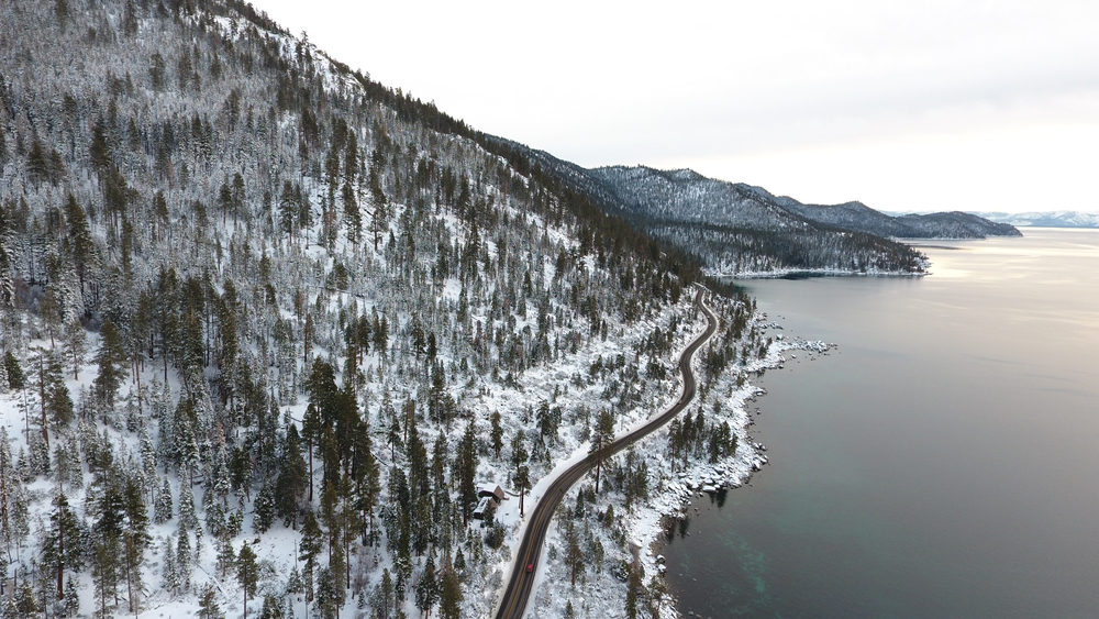 A winding road along the shores of Lake Tahoe in snowy winter.