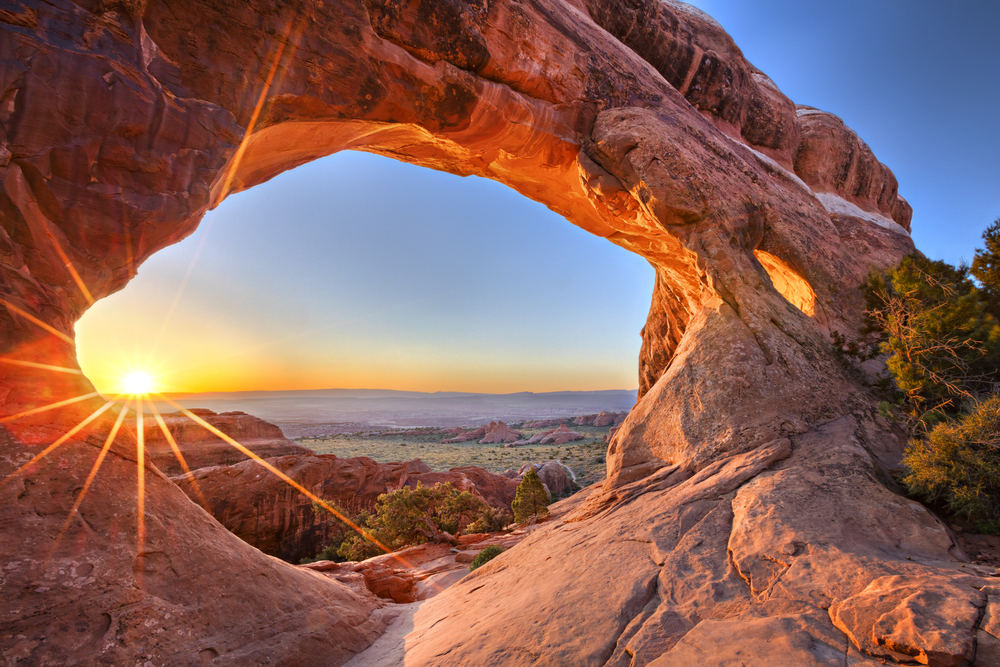 Sunrise seen through the Partition Arch, in Arches National Park.