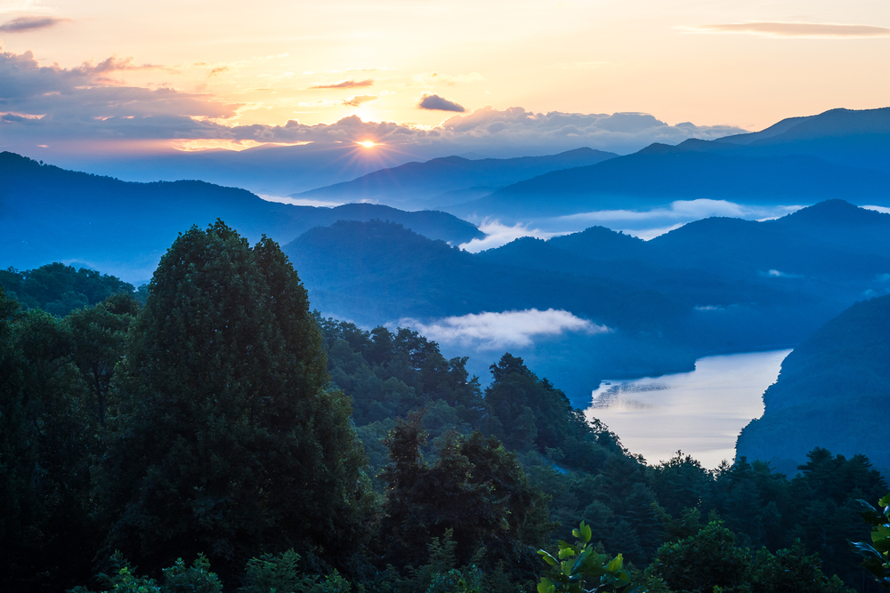 Sunrise over Great Smoky Mountains National Park, the mountains silhouetted in shadow.