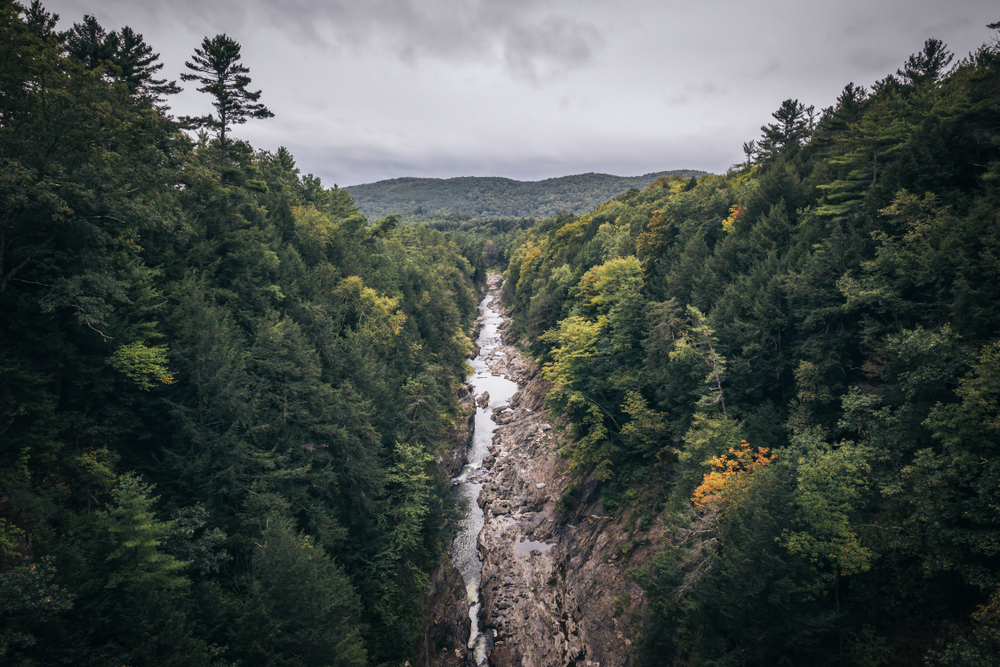 Looking out over Quechee Gorge and the Ottaquechee River at the start of fall in Vermont.