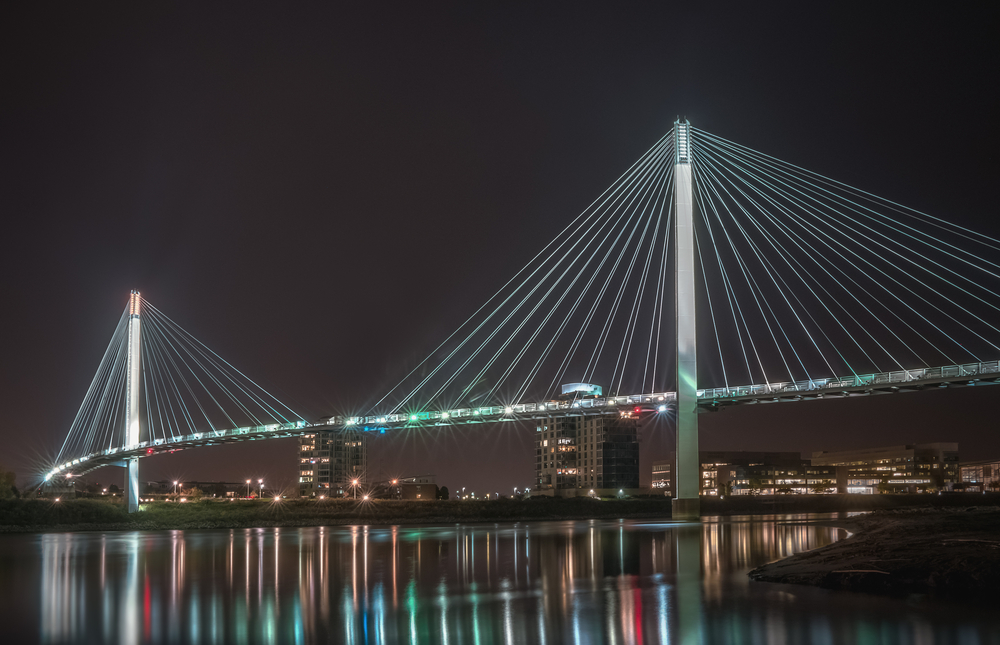 Bob Kerrey Pedestrian Bridge between Omaha, Nebraska, and Council Bluffs, Iowa, lit up at night.