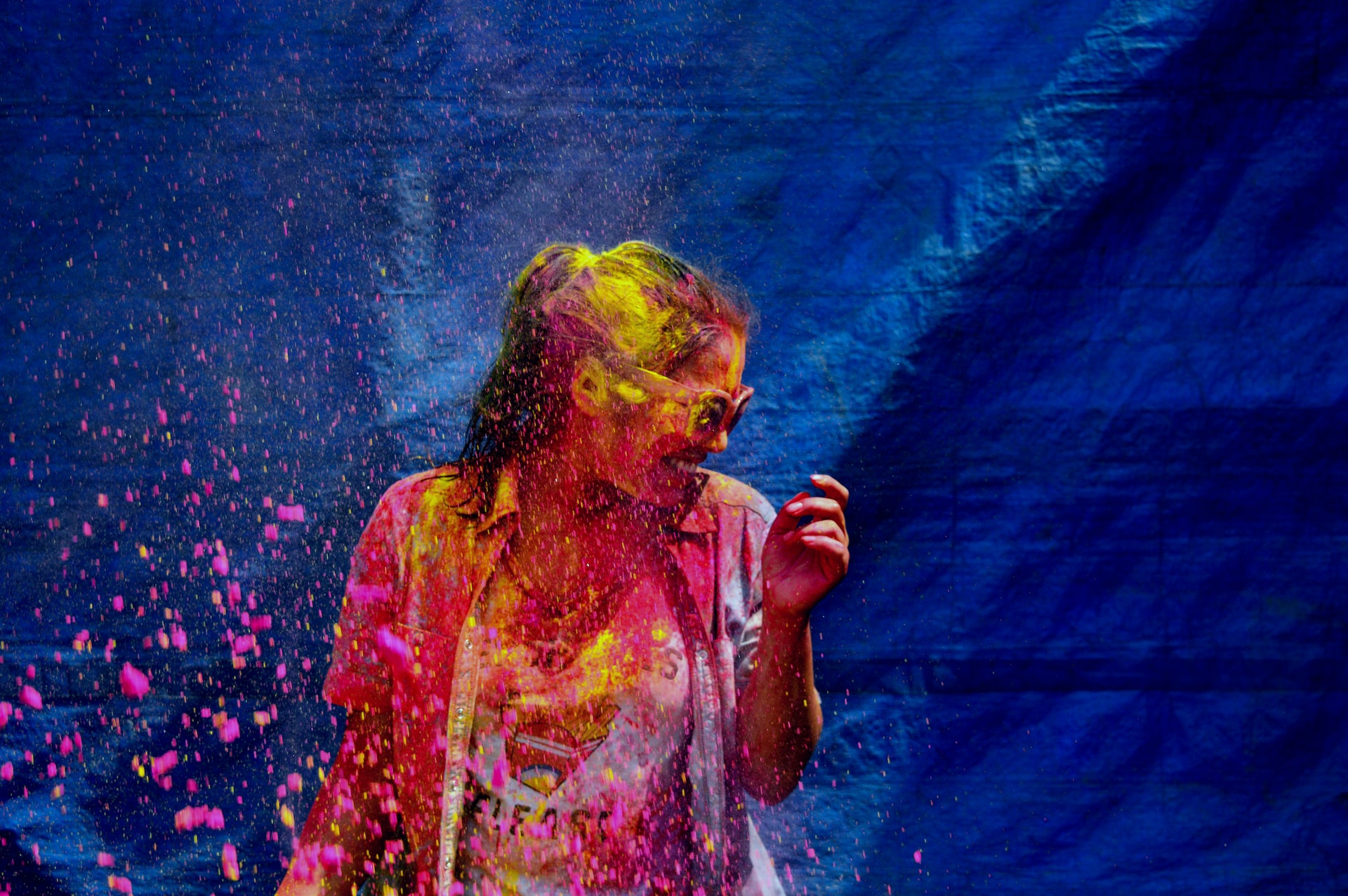 A girl covered head to toe in colorful powder.