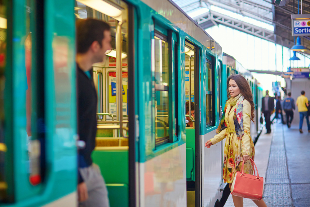 Young beautiful Parisian woman on a subway station, running to catch her train on the platform.