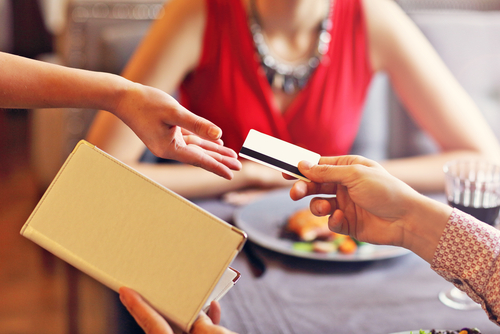 A couple paying a restaurant bill with a tip.