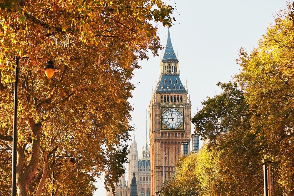 Big Ben surrounded by changing leaves in autumn.
