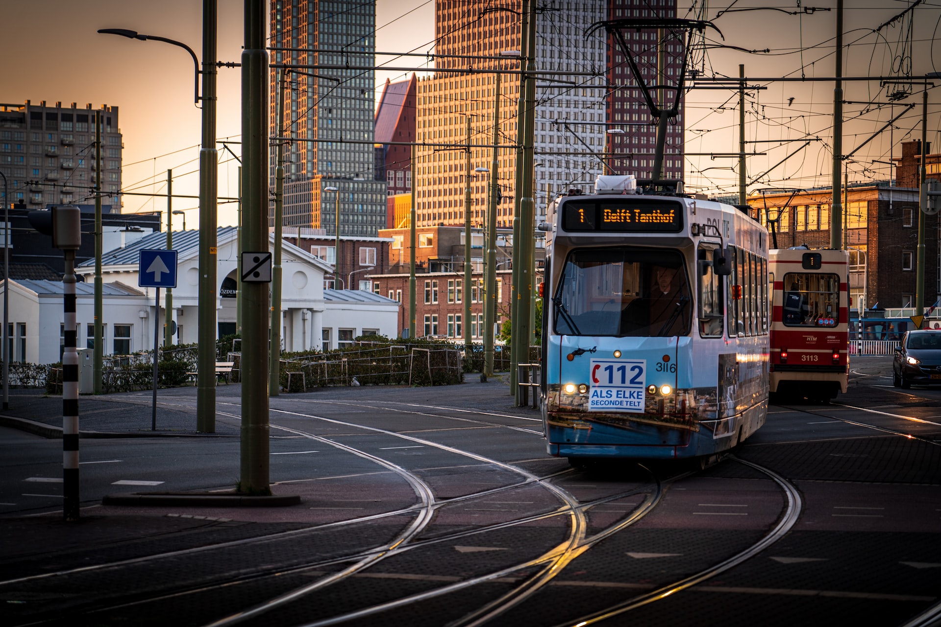 The Hague: trams gliding on tracks on city streets in the sunset.