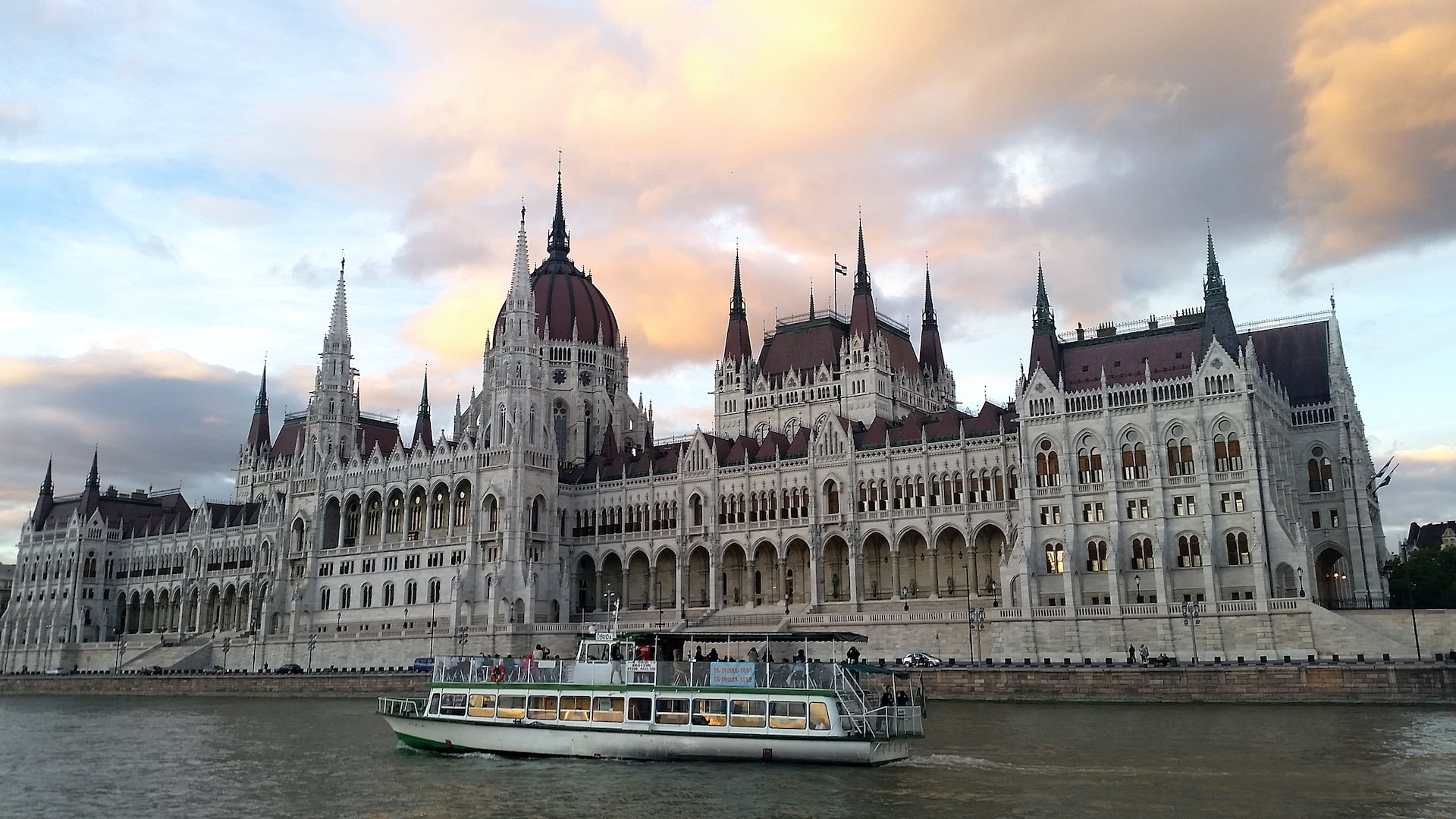 Budapest Parliament seen from a Danube boat cruise at sunset.