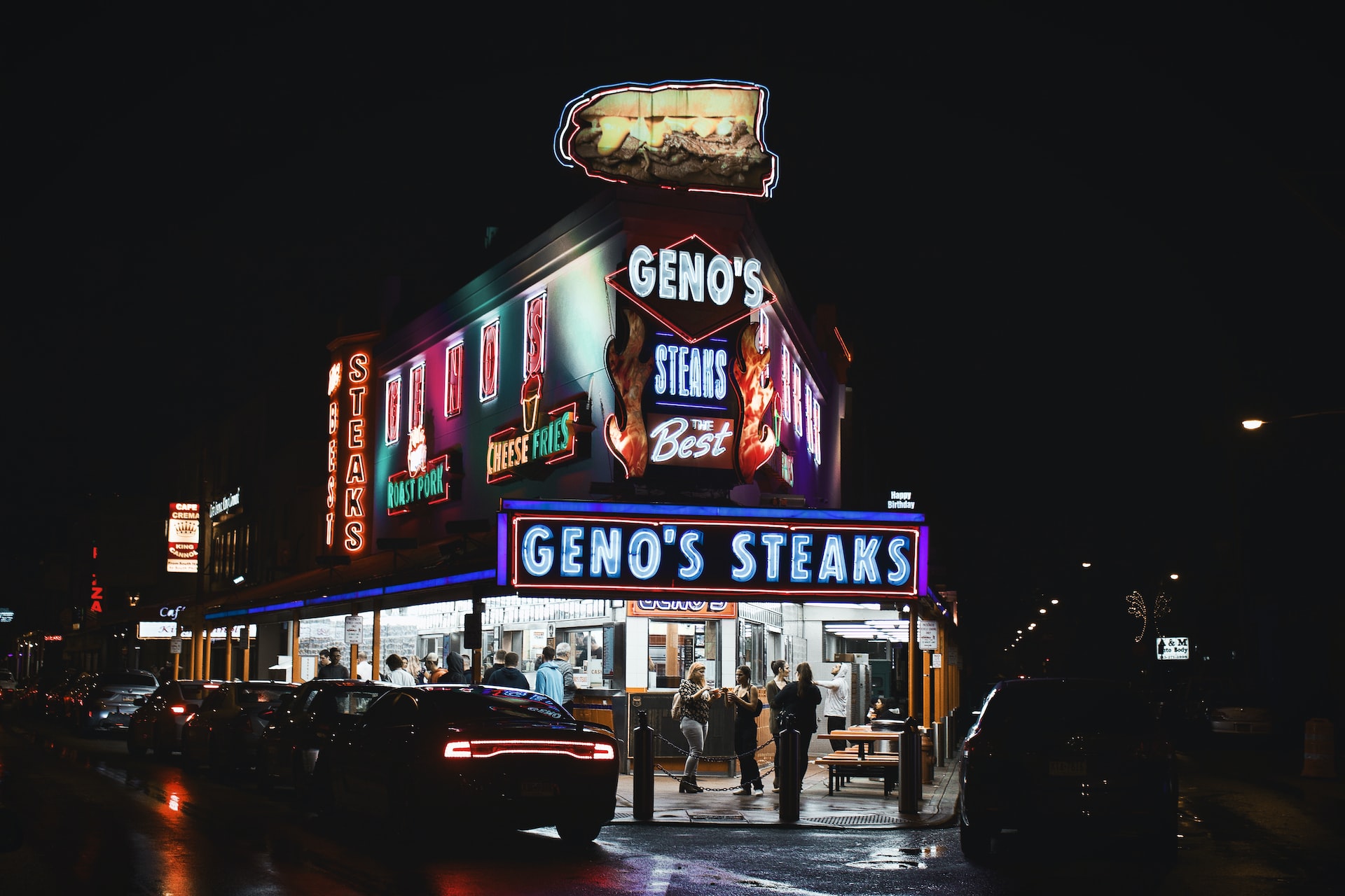 People eating cheesesteaks from Geno's Steaks in Philadelphia.