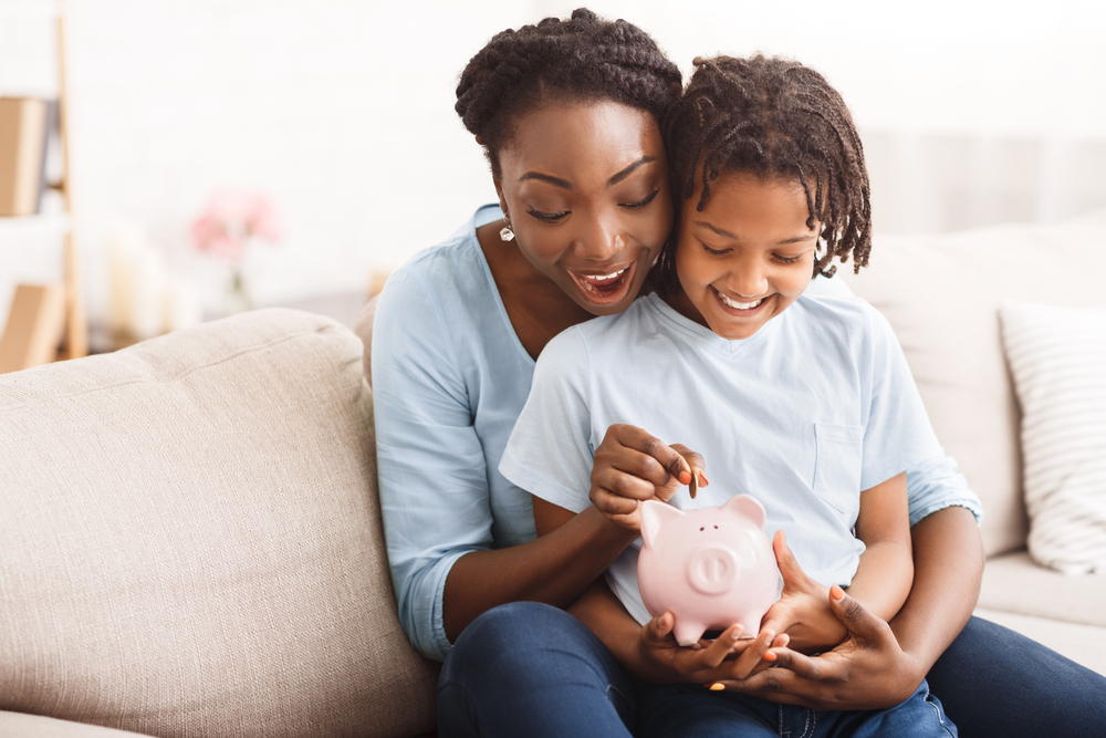 Excited family putting money into piggy bank.