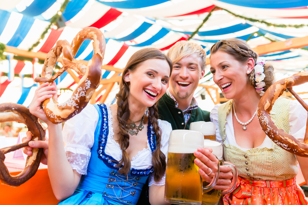 Men and women wearing lederhosen during a traditional Oktoberfest celebration.