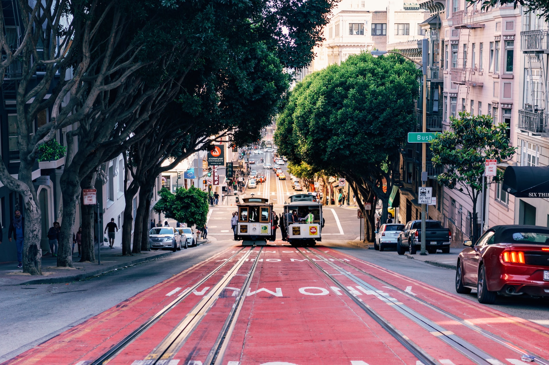 Two trolley cars on a steep hill road in San Francisco.
