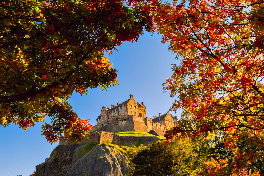 Edinburgh Castle surrounded by changing leaves in fall.