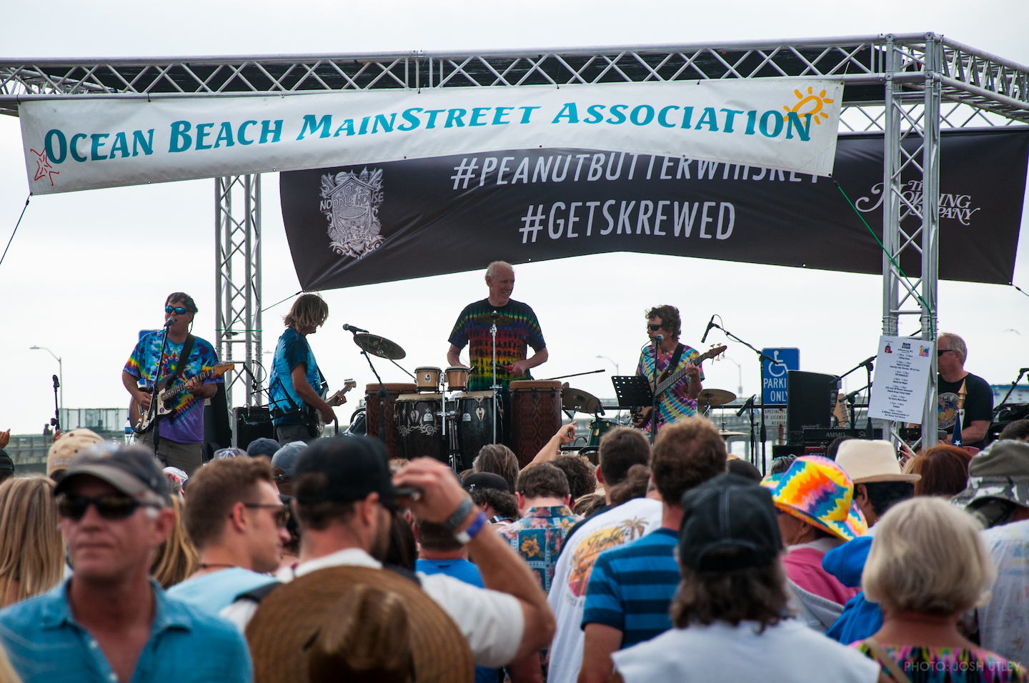 A Dead Head cover band playing on stage in front of an outdoor audience.