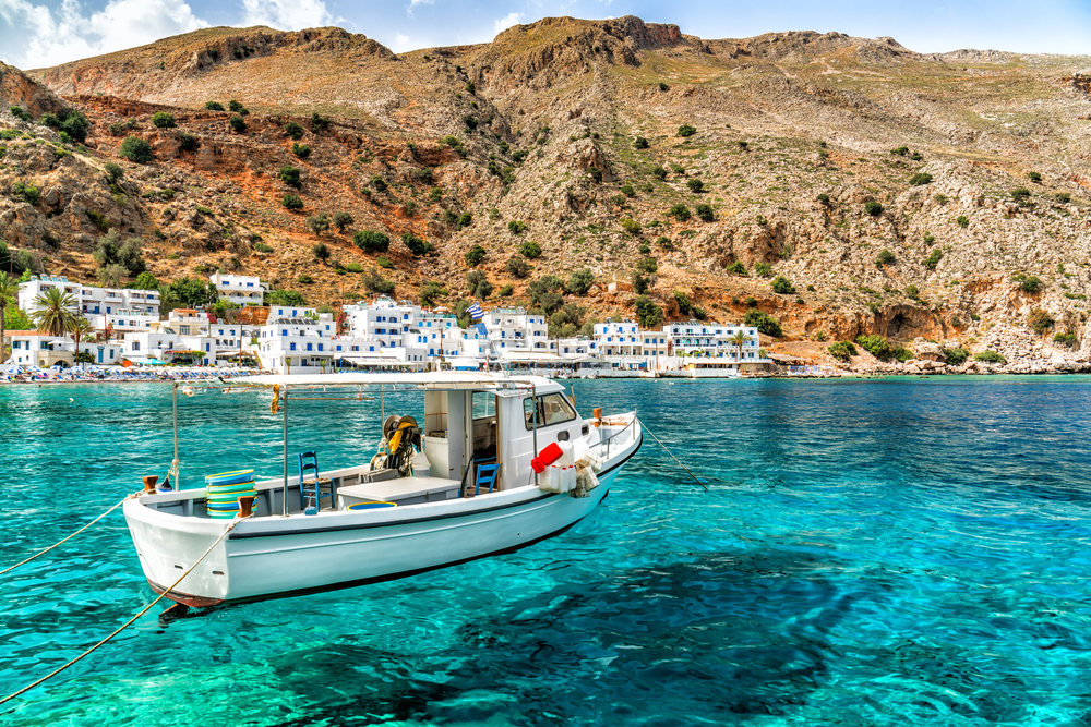 A boat floating in crystal-clear water off of Crete.