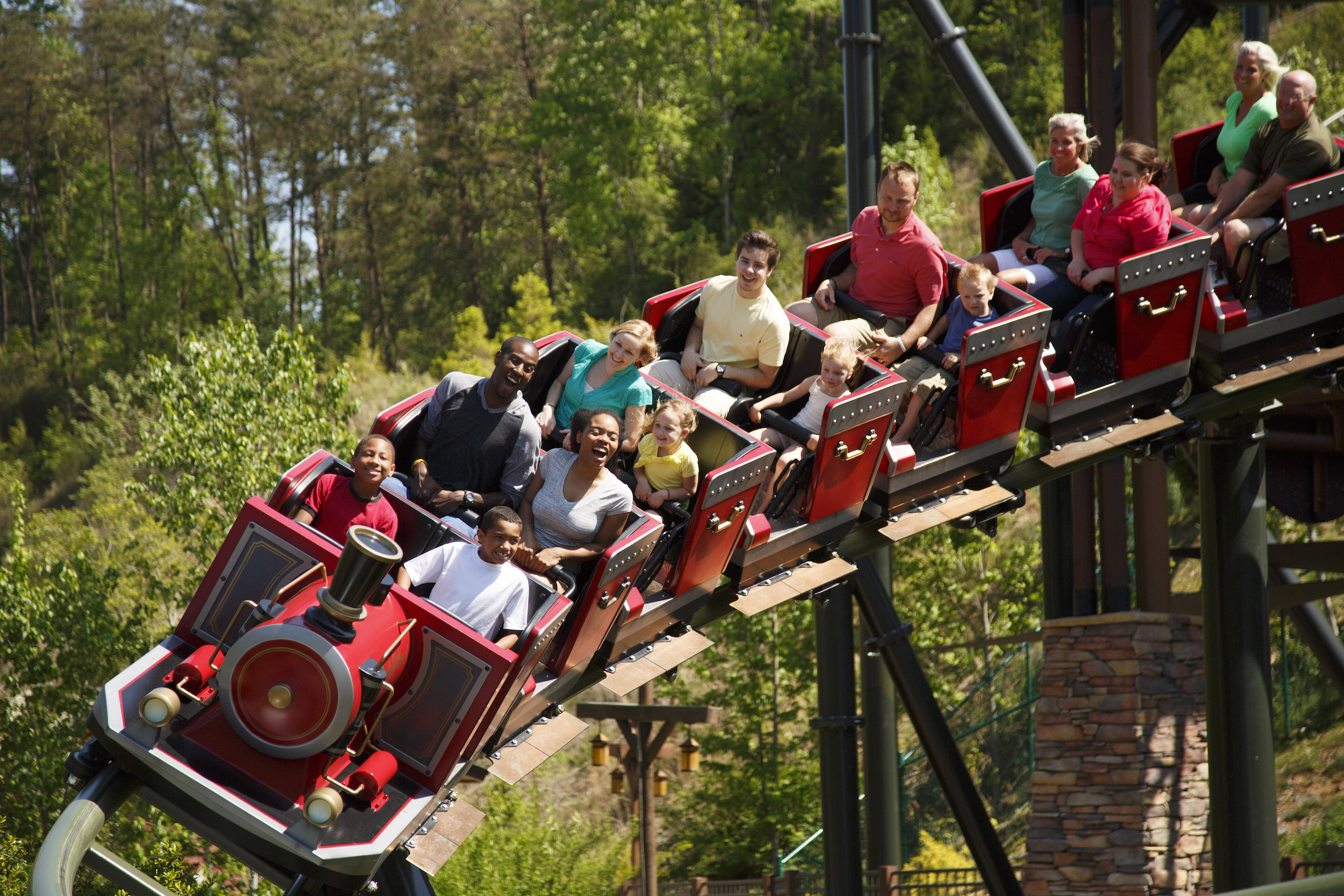 Adults and children riding a red rollercoaster at Dollywood.