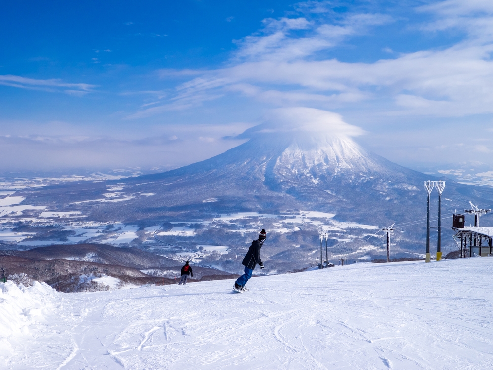Snowy volcano with cap cloud viewed from a ski resort (Niseko, Hokkaido, Japan).