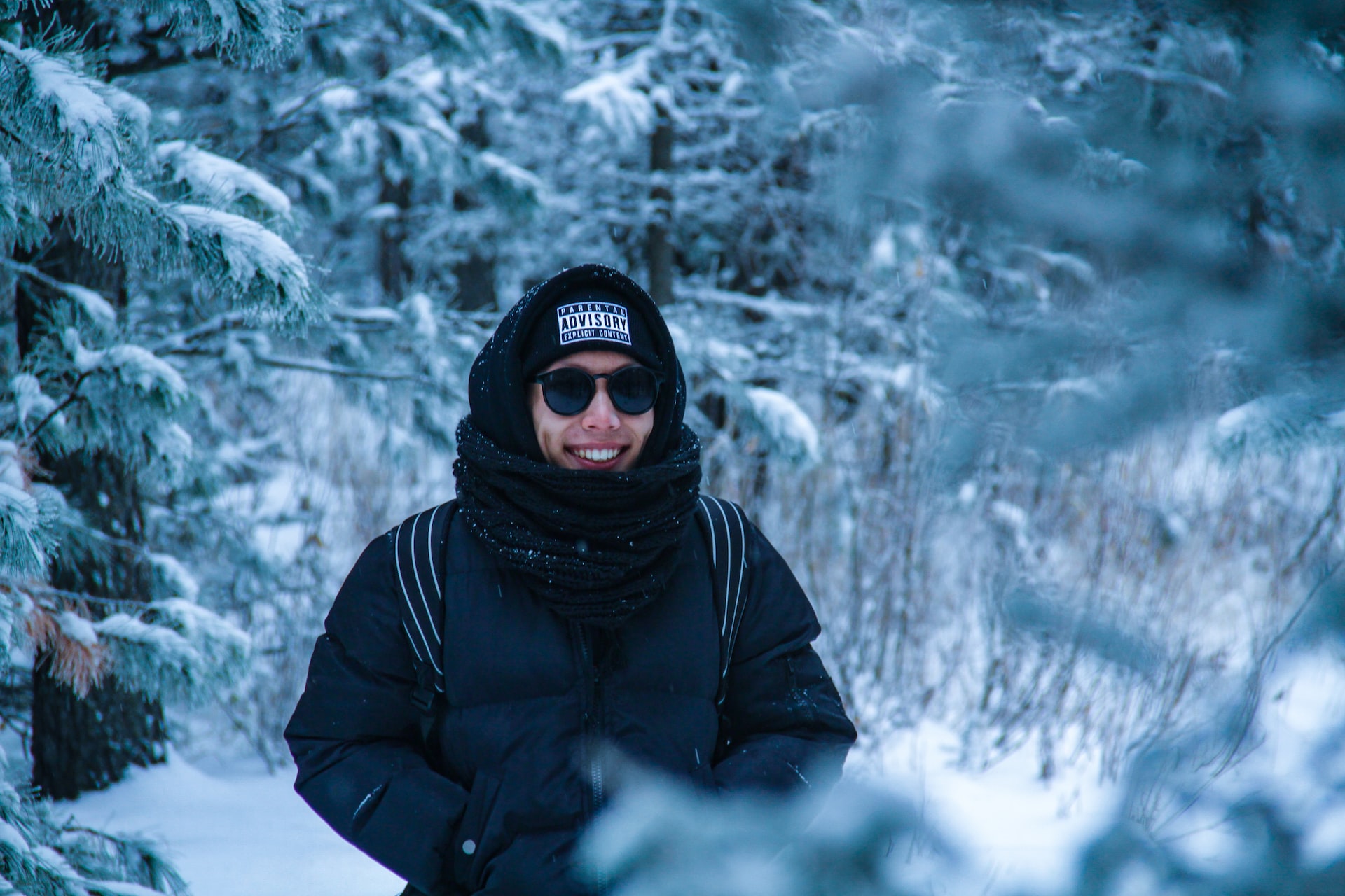 A woman smiling surrounded by snowy wilderness.