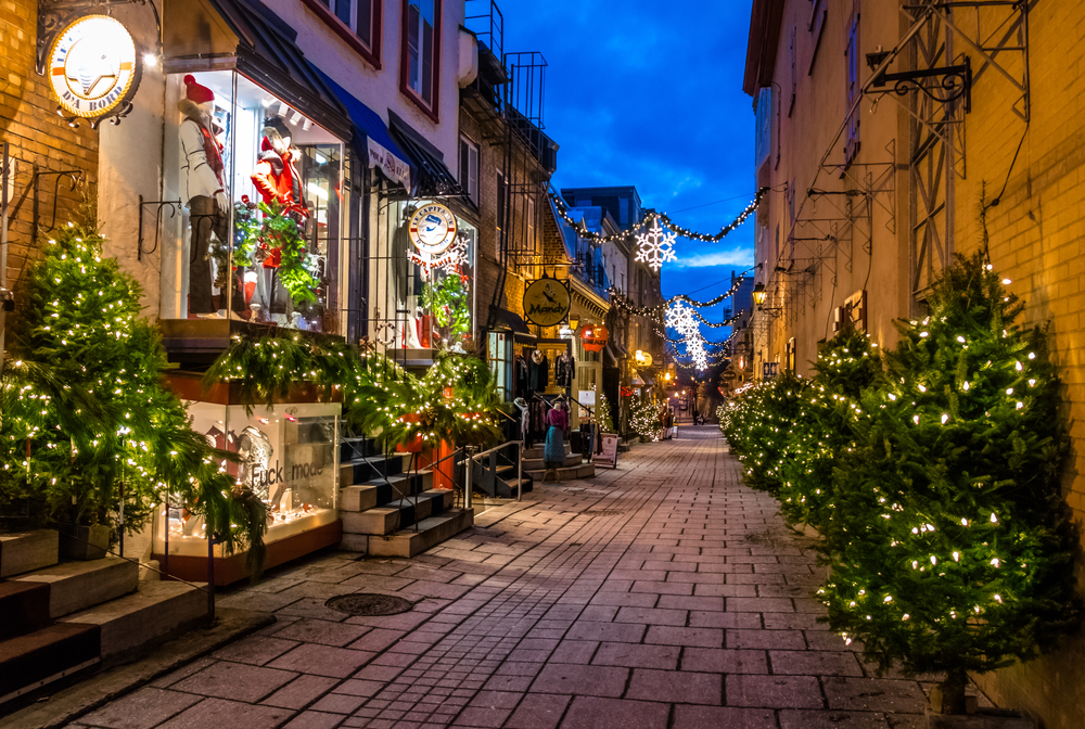 A Quebec alley decorated in trees and lights during Christmas.