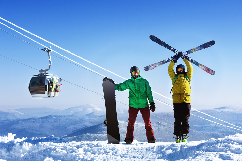 A skiier and snowboarder on the slopes.