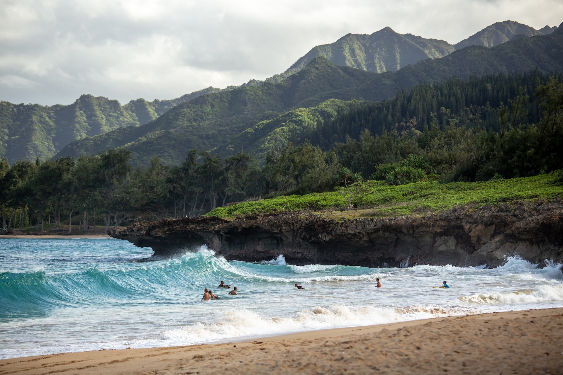 Surfers enjoying the majestic views and crystal-clear water in Hawaii.
