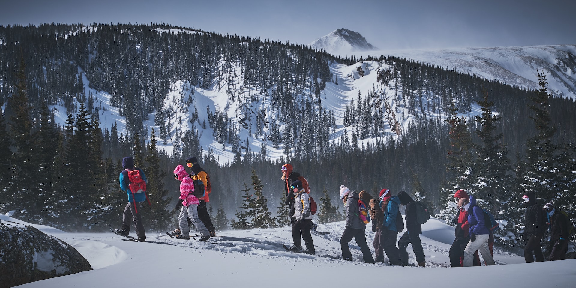 People snowshoeing up the side of a mountain in Colorado.