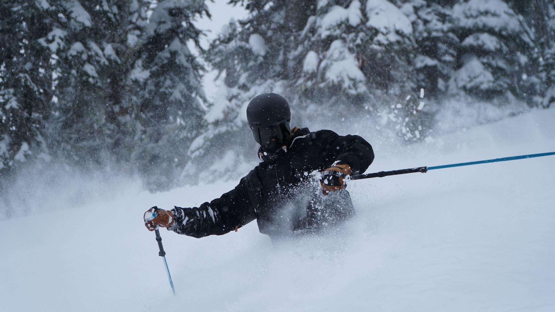 Man wearing dark visors skiing through backcountry.