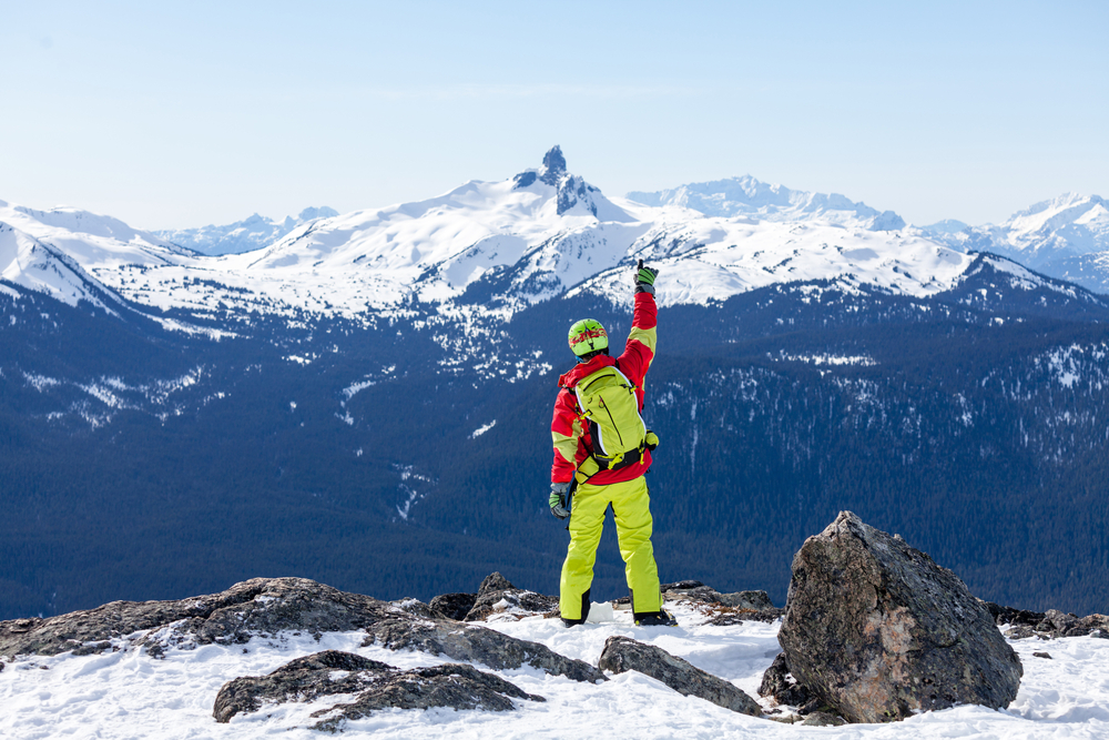 A colorful skier at the peak of a Canadian ski resort.