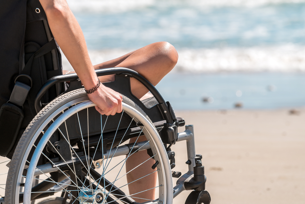 A woman using a wheelchair at the beach.