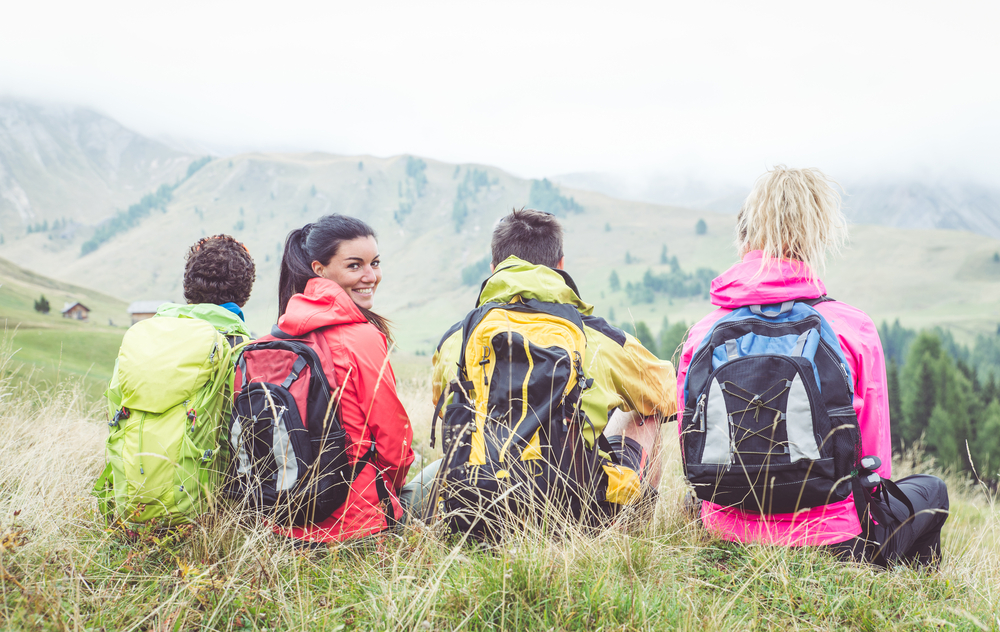 four-backpackers-sitting-on-hill