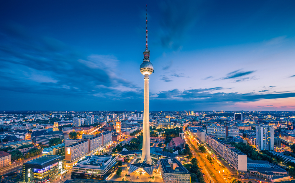 The Berlin TV Tower glowing high above the skyline at night.