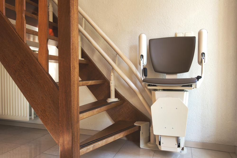 Automatic stairlift on staircase for elderly or disability in a house, taking people up and down.