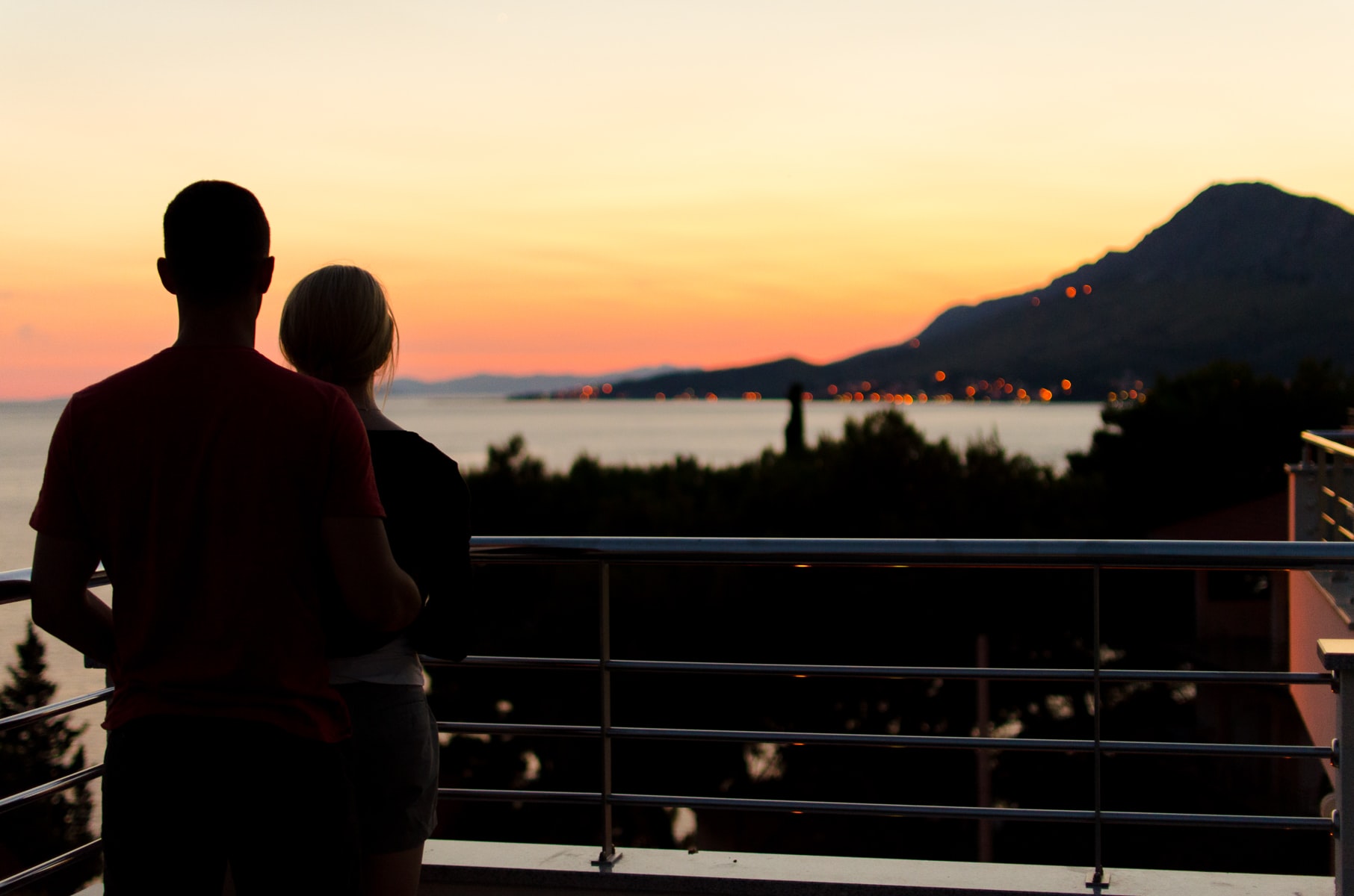 A couple watching the sunset on a balcony.