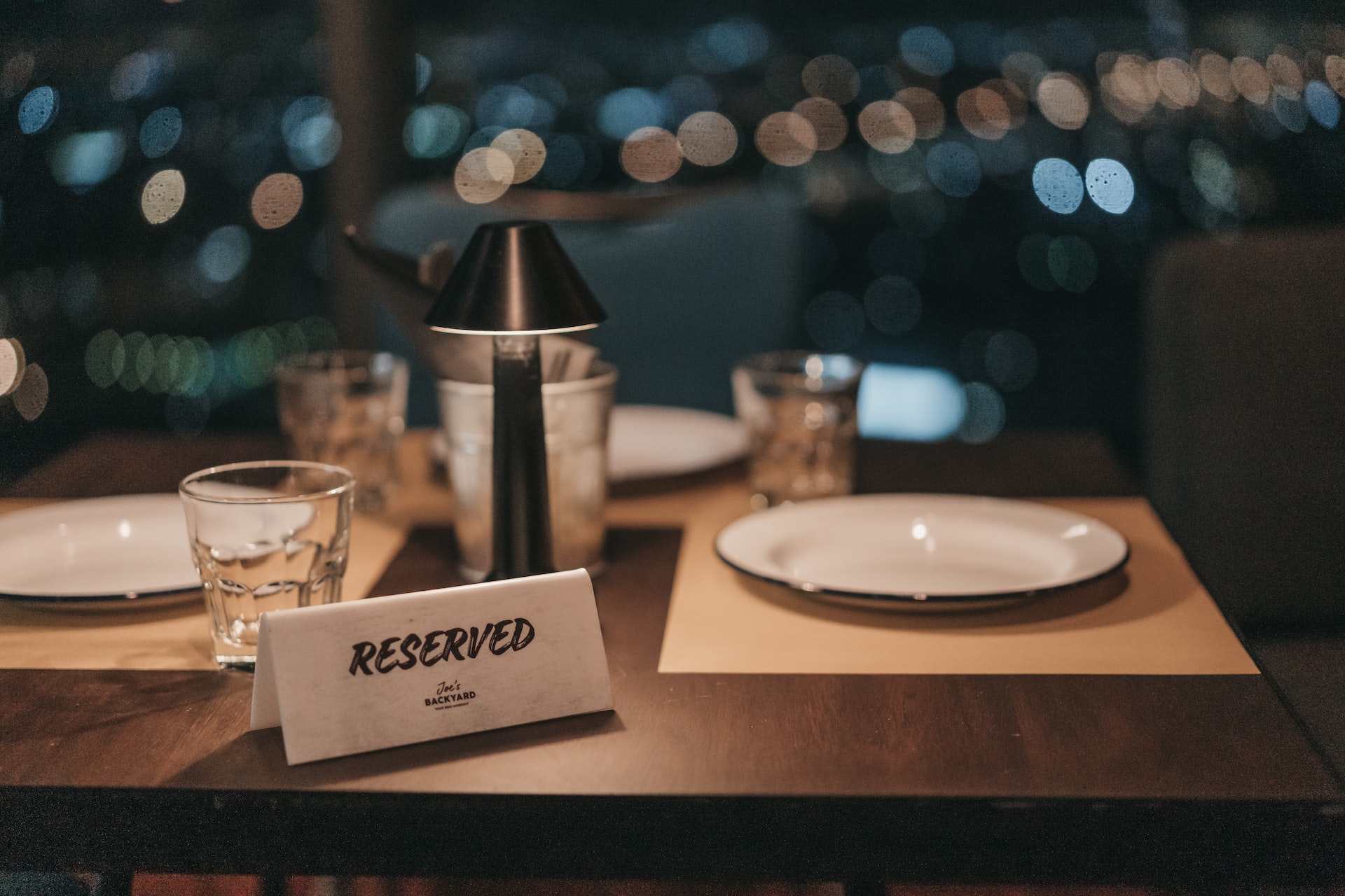 White tablecloth dinner table at night with a reserved sign.