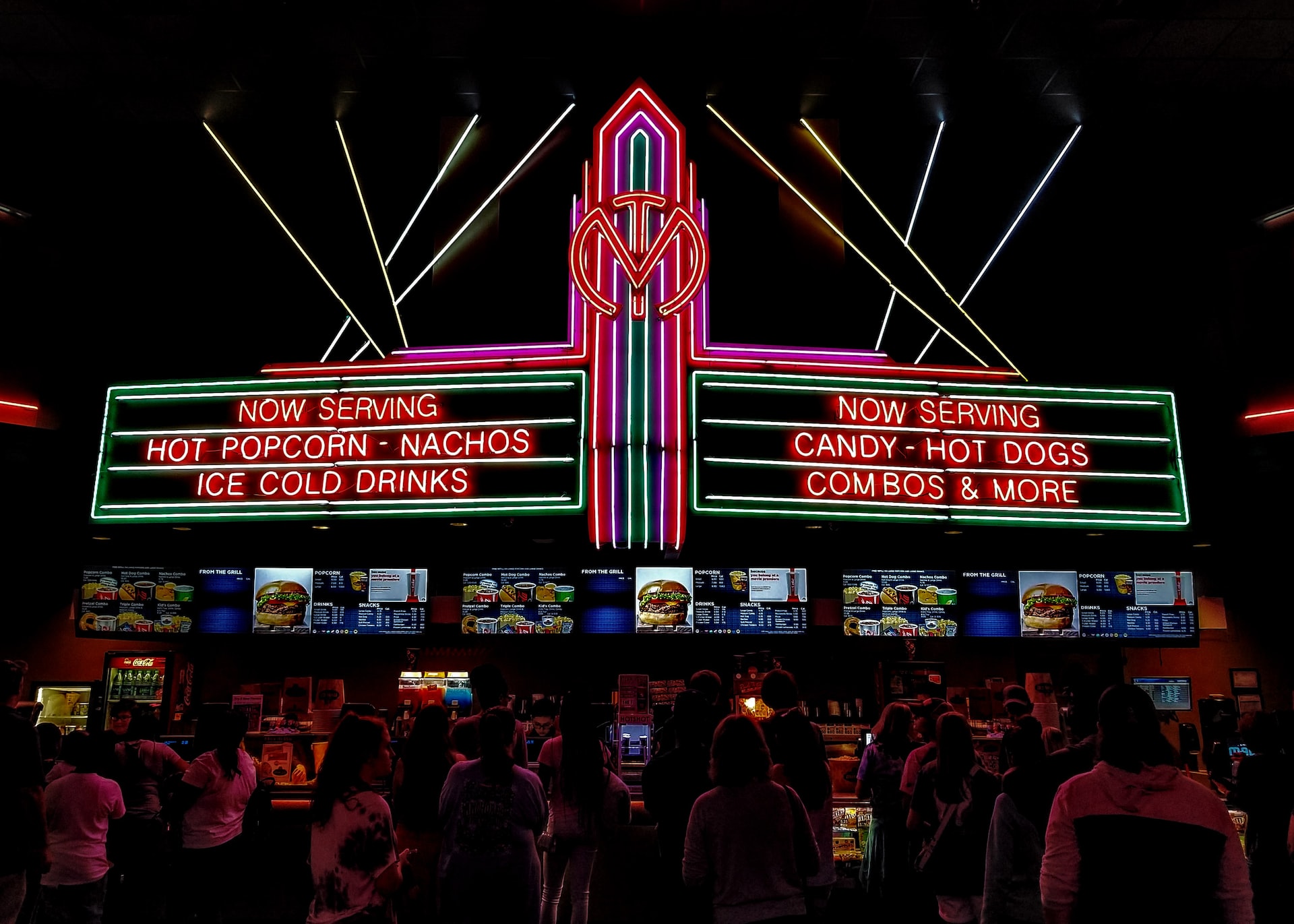 Movie theater concession lit up with neon lights.