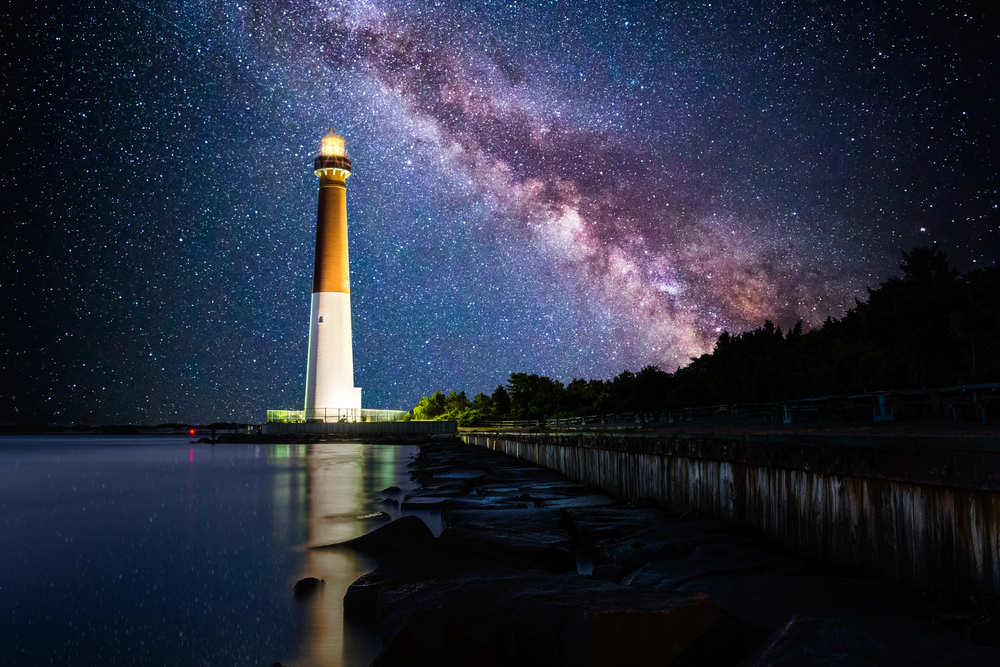 Barnegat Lighthouse under a starry night sky; Barnegat Lighthouse is a historic lighthouse located in Barnegat Lighthouse State Park in New Jersey.